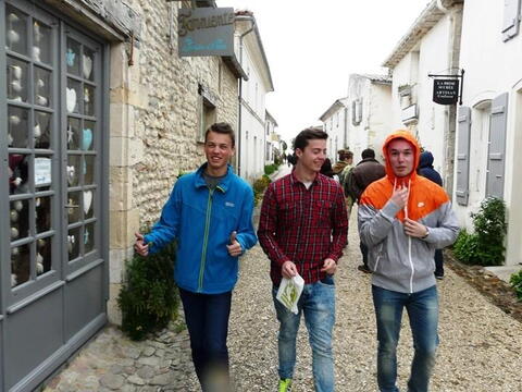 V uličkách Talmont-sur-Gironde. Všimněte si jam Michaelovli ladí modrá bunda s nápisem nad jeho hlavou, ozdobami ve dvřích obchodu a samozřejmě s barvou jeho očí. :-)