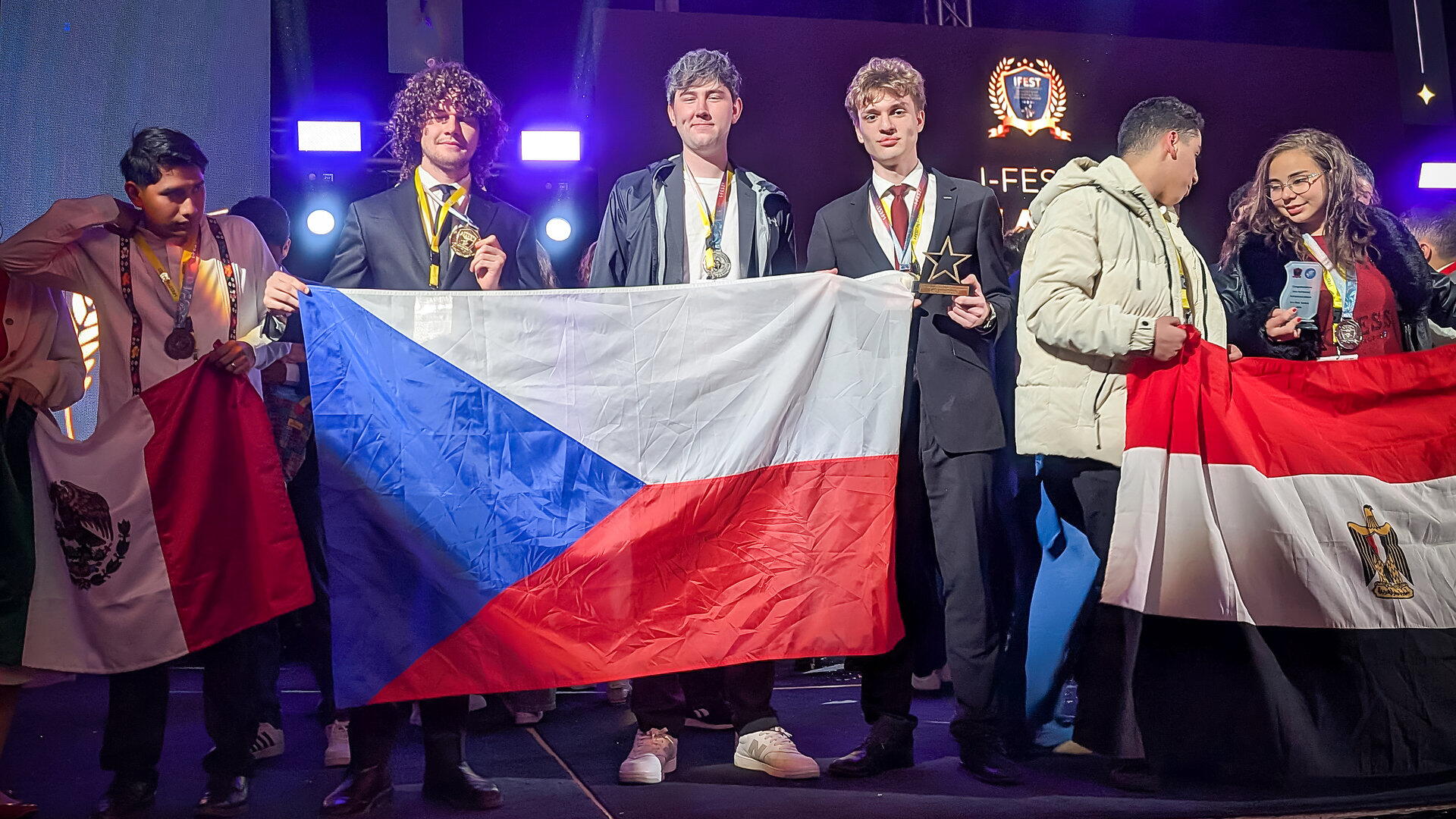 Kluci s vlajkou na pódiu